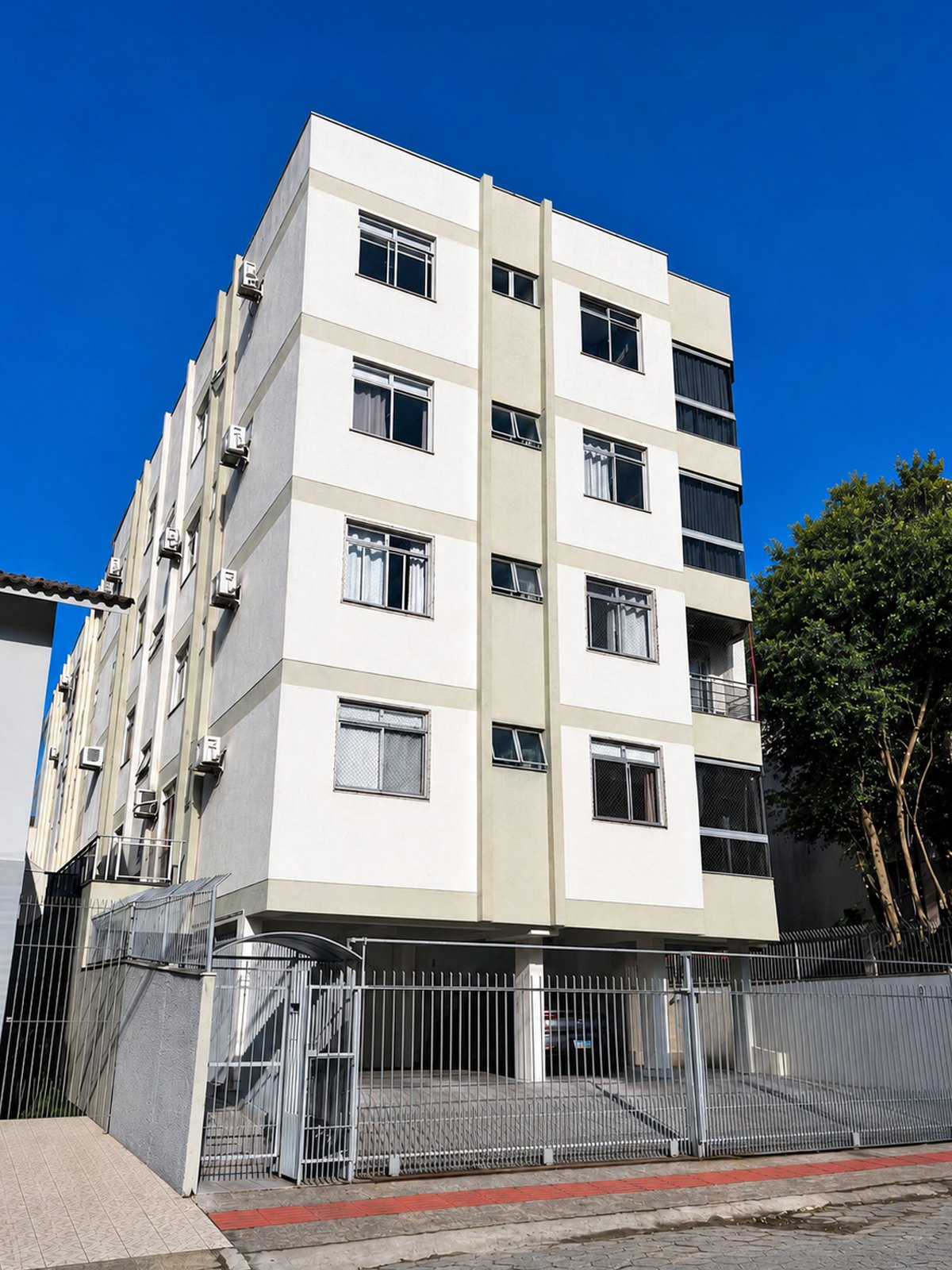 Fachada do prédio com portão e cerca