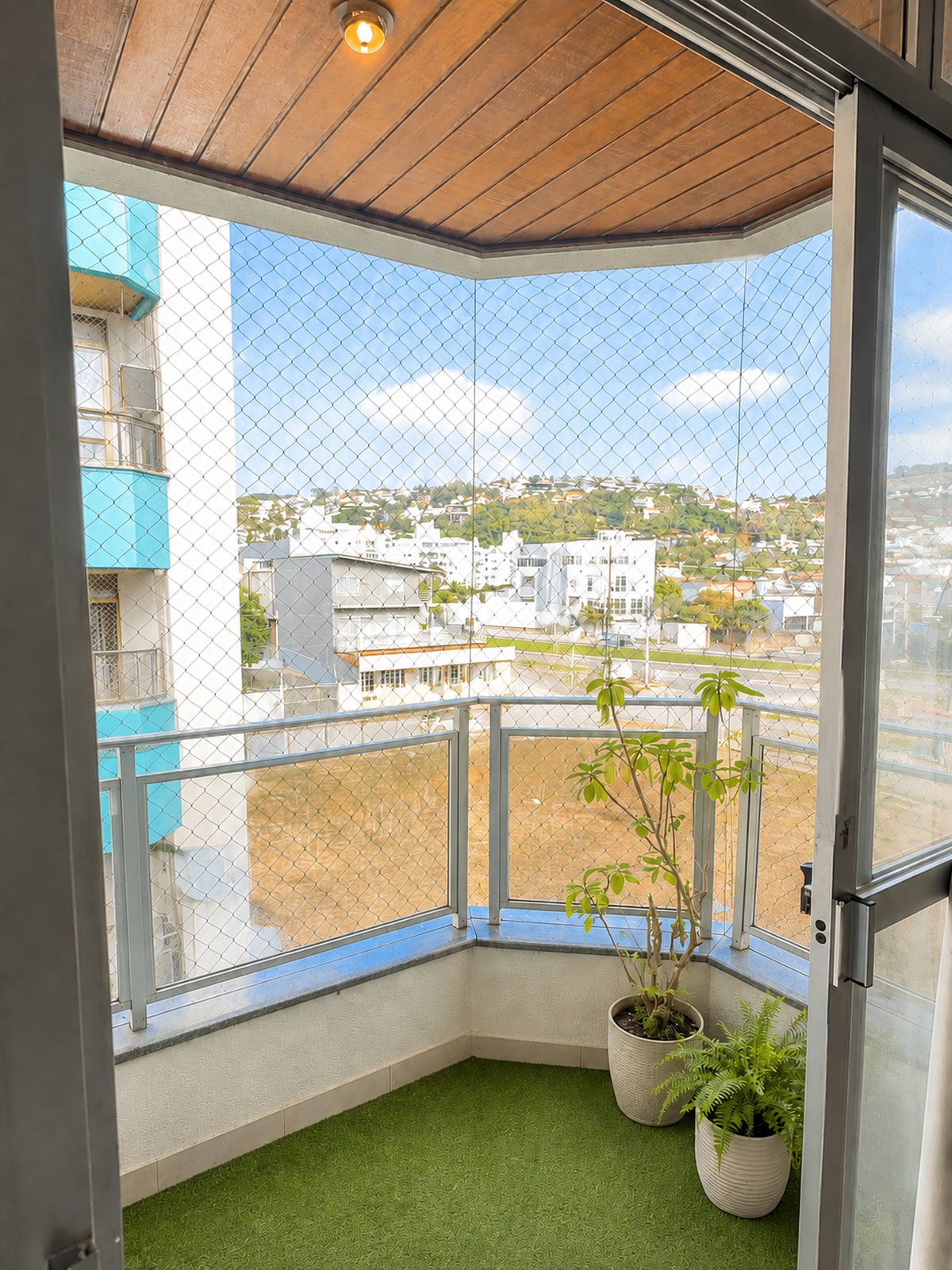 Sacada na quina do prédio, fechada com tela