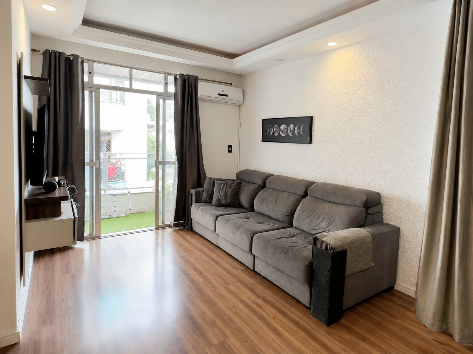Sala de estar com sofá e porta da varanda